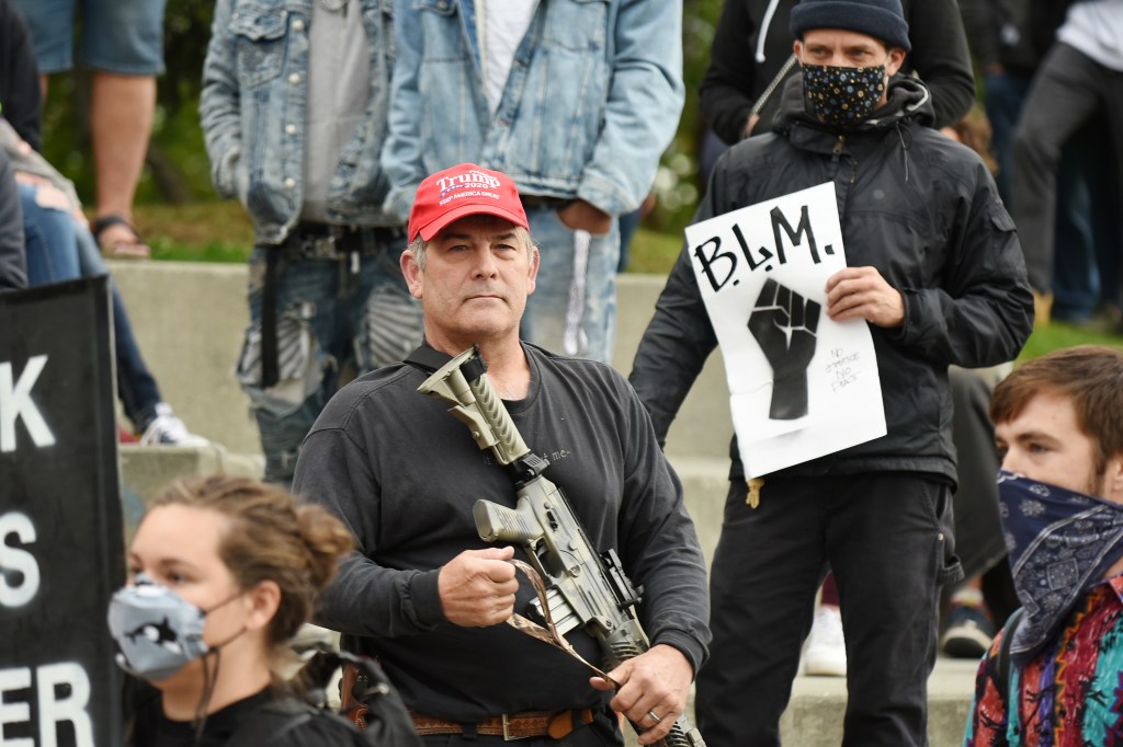 Counter-protester wearing Donald Trump campaign paraphernalia at the March on Alaska