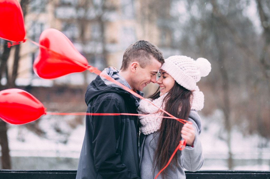 Smiling couple heart shaped balloons