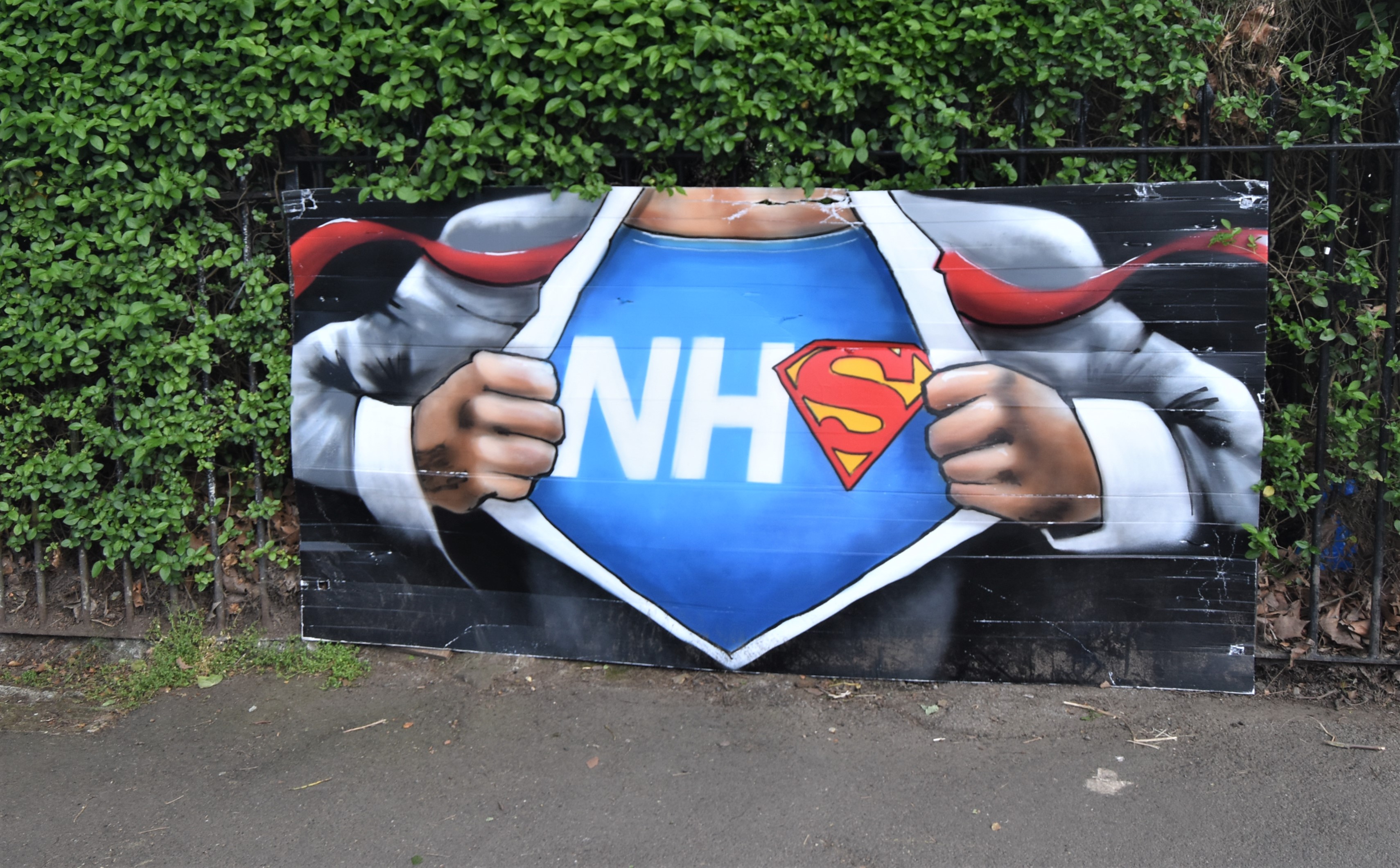 A graffiti-style image of an NHS worker as Superman
