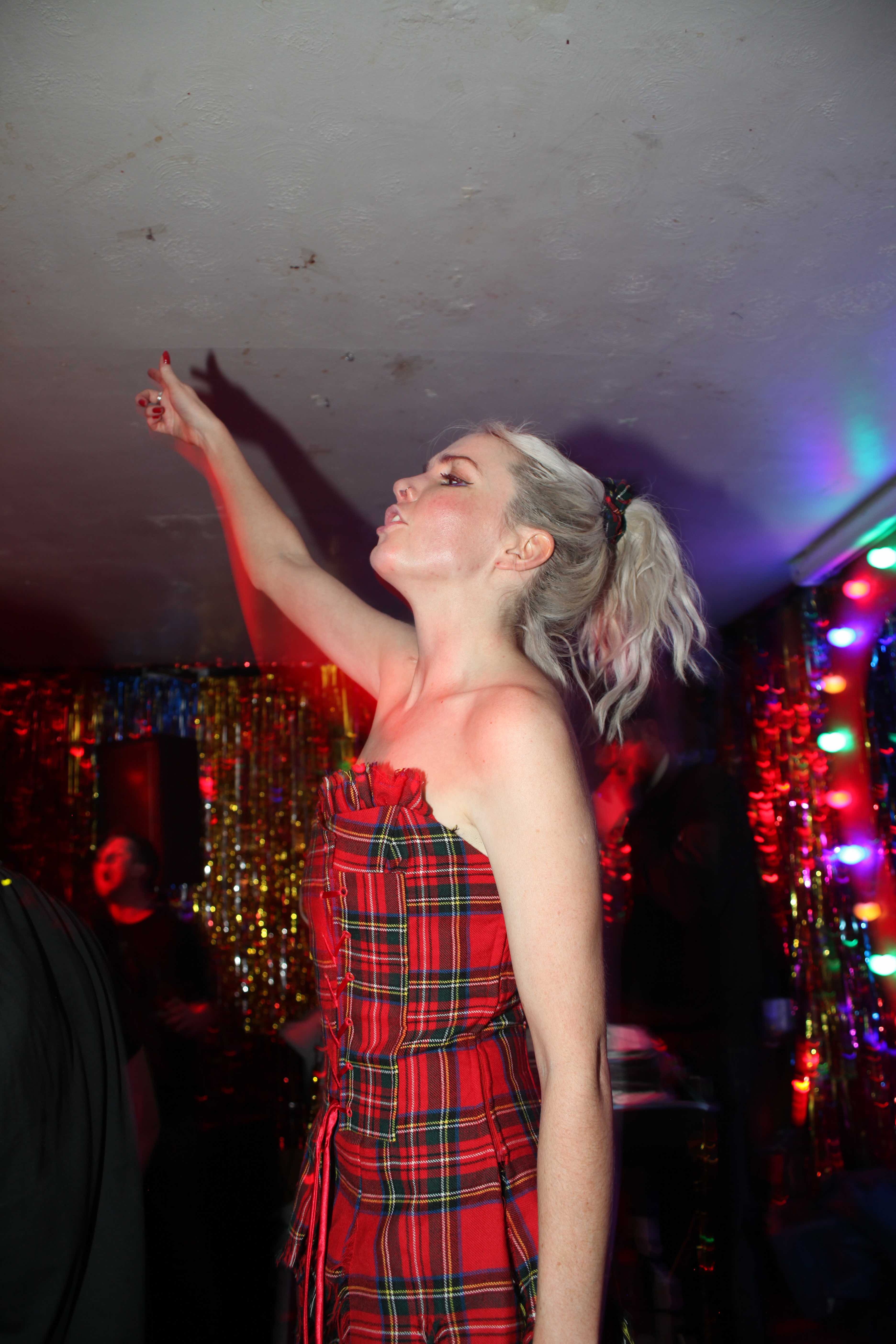 Alex Haddow wearing a red and green tartan dress at Indie Amnesty