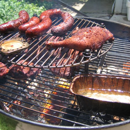 Chicken and sausages cooking on a barbecue