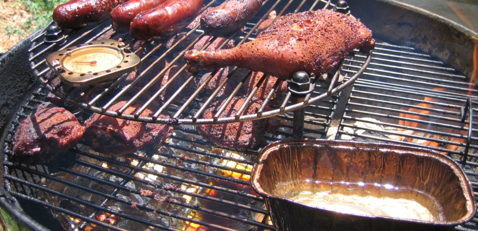 Chicken and sausages cooking on a barbecue