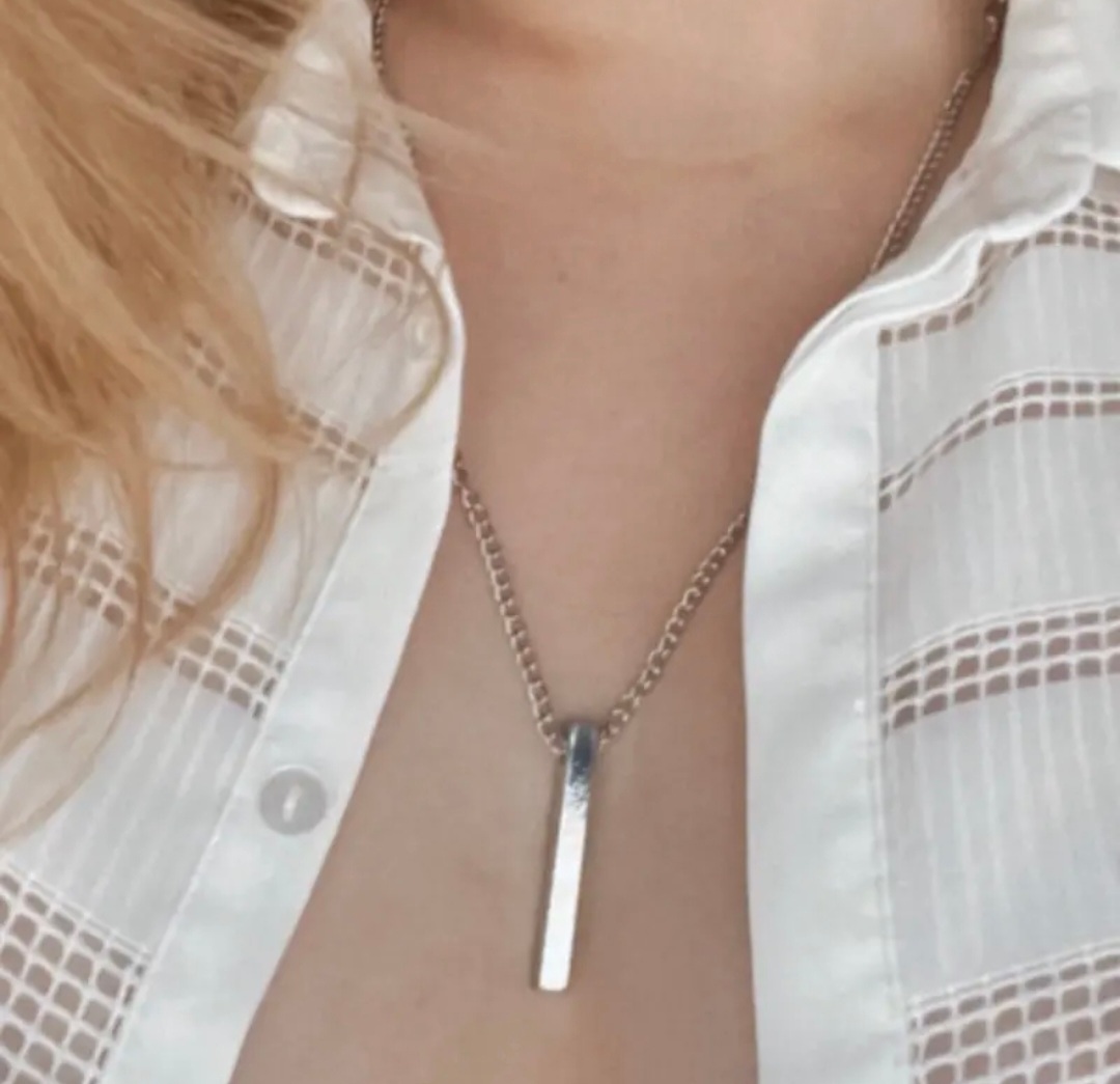 A blonde woman wears the Ingot necklace
